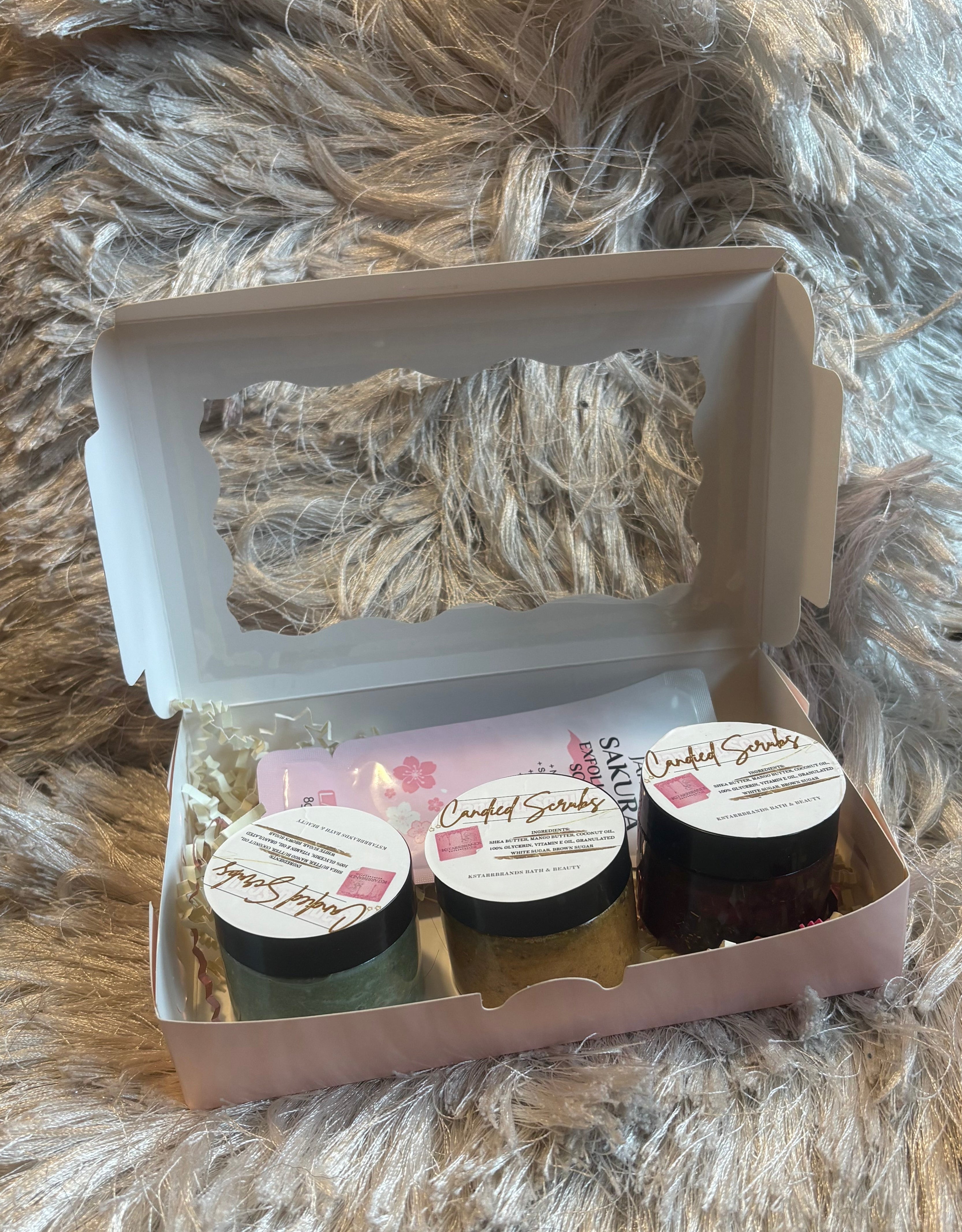 Three small jars in a cardboard box on a fluffy gray surface